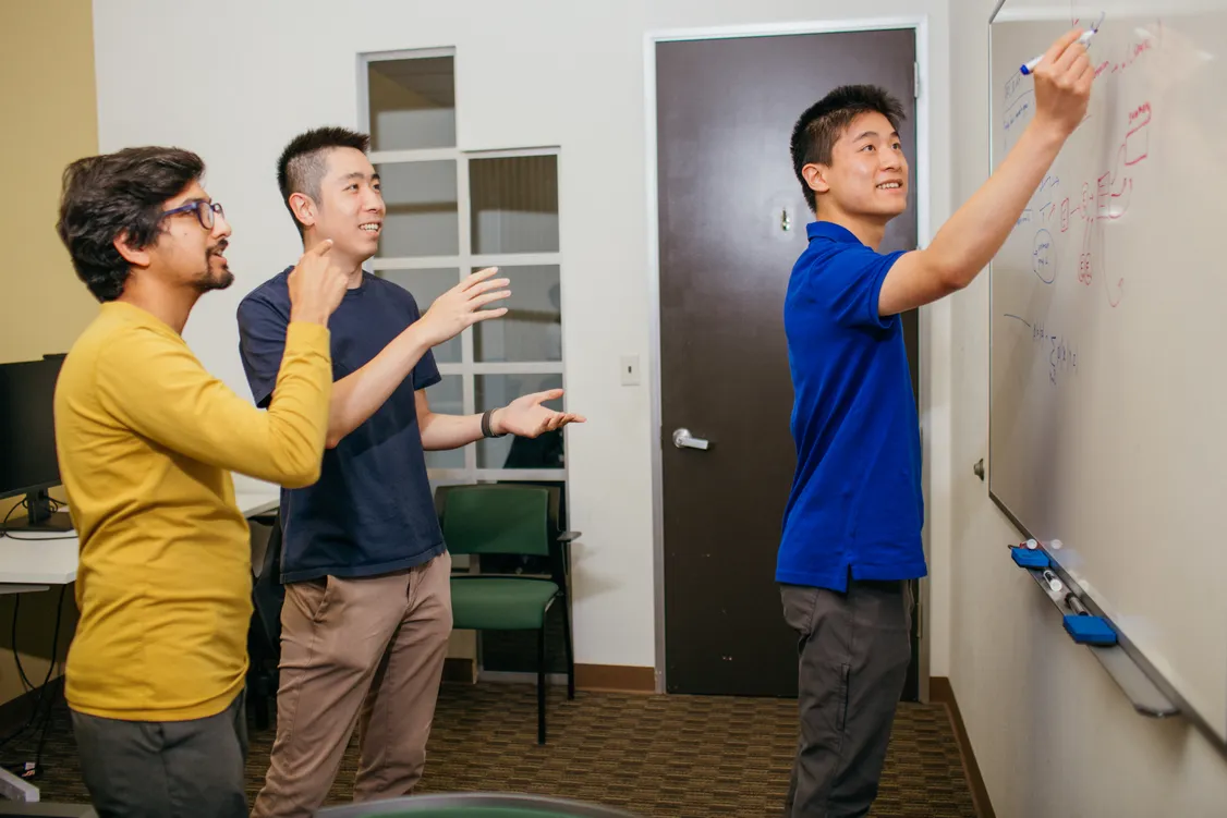 Samaya team brainstorming around a whiteboard